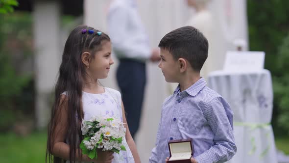 Cute Confident Middle Eastern Flower Girl and Ring Boy Posing on Marriage Ceremony Outdoors alt