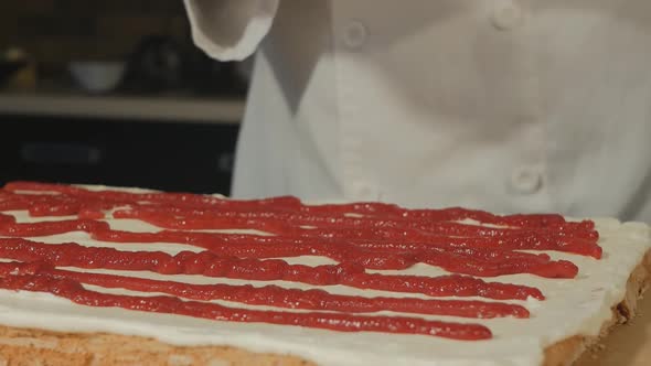 Pastry Chef Squeezes the Jelly Onto the Blank for the Meringue Roll