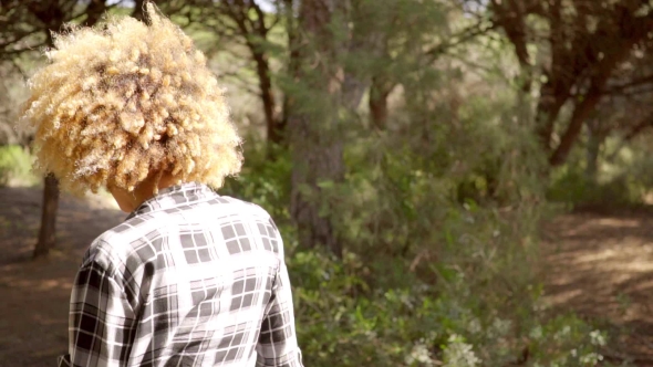 Back View Of A Walking Woman On The Forest Road. alt