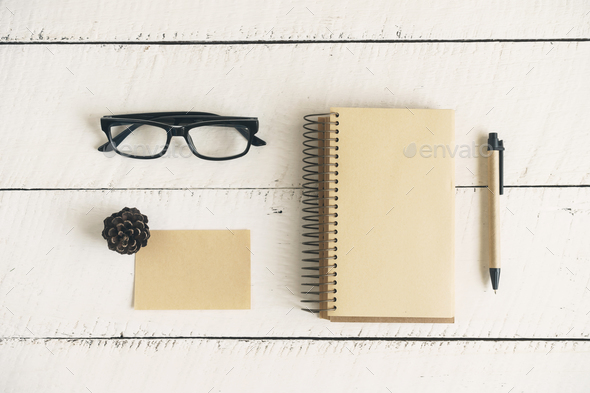 Blank note book with eye glasses and pen on white wooden background,