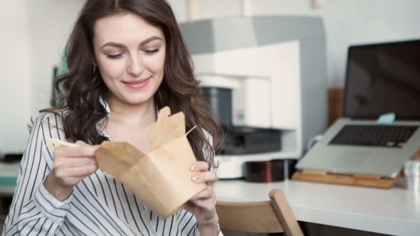 Business Woman Enjoying Fresh Salad For Lunch Break At Office Desk