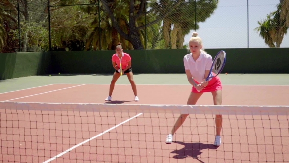 Two Pretty Women Playing a Game Of Tennis Doubles alt