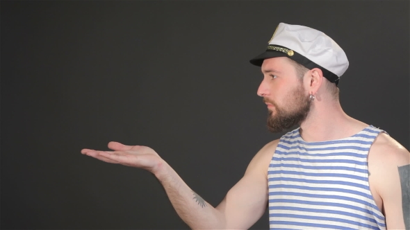 Side View Of Bearded Captain Sends Air Kiss alt