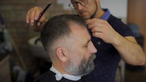 Hairdresser  Cuts   Hair  With Scissors On Crown Client In  Professional  Hairdressing Salon alt