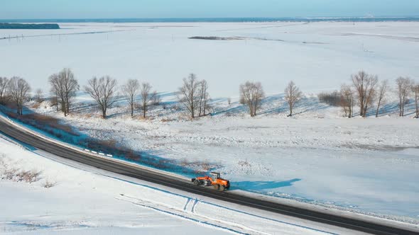 Aerial View Snow Removal Tractor Clears Road From Snow alt