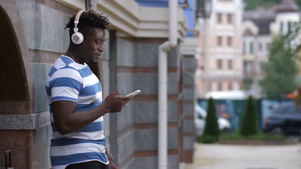 Man with Headphones Listening Music on Smart Phone alt