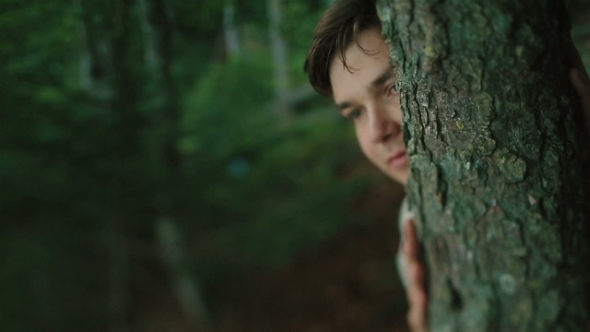  Of Young Carpathian Peasant Watching Someone In The Mountain Forest And Hiding Face By The Tree
