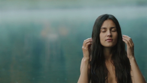 Young and Beautiful Sexy Girl With Long Dark Hair With Clean Blue Water of Mountain Synevir Lake