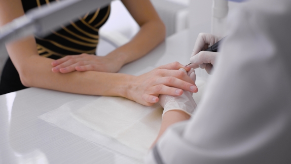 The Master Uses an Electric Machine To Remove The Nail Polish