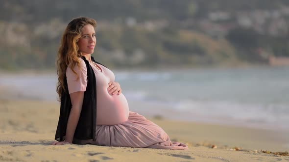 Caucasian Woman Sitting By the Ocean on a Sandy Beach alt