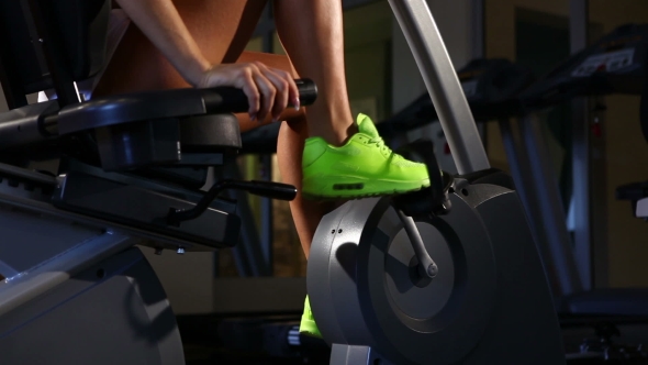 Female Legs Riding At Stationary Bike In The Gym