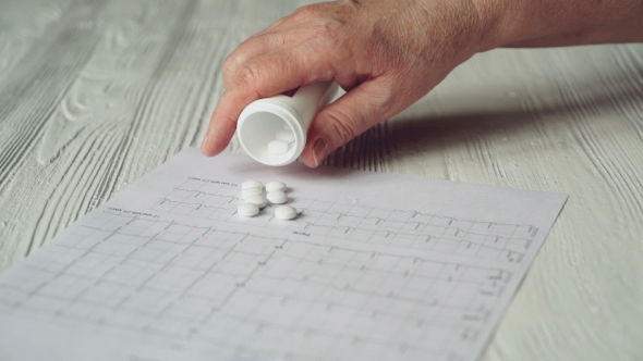 Hand Pours Out Pills From The Bottle On The Table alt