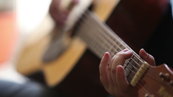 Little Boy Is Playing The Guitar 