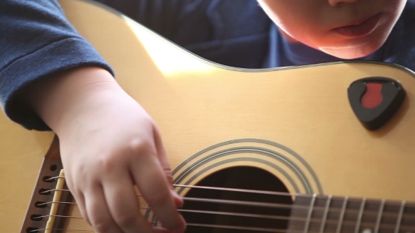 Little Boy Is Playing The Guitar 