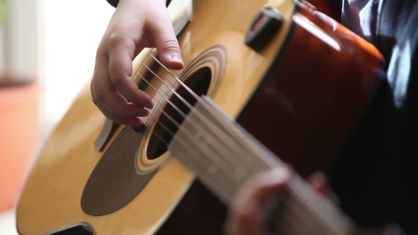 Little Boy Is Playing The Guitar 