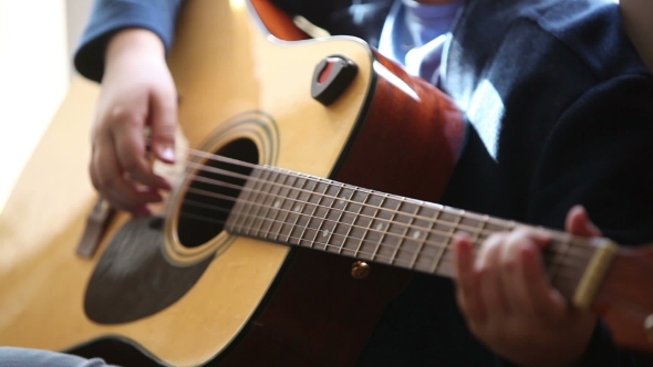 Little Boy Is Playing The Guitar 