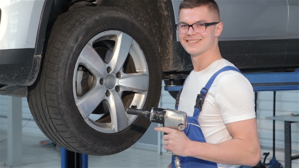 Mechanic Holds Pneumatic Wrench In His Hand alt