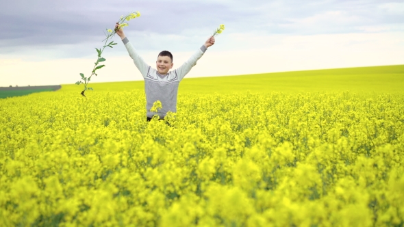 Cheerful Boy Cuts Rape On Rape And Sky Background.  alt
