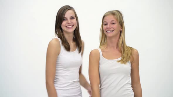 Two Young Girlfriends Against A White Background