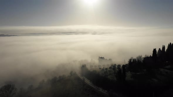 Aerial view of morning fog over forest in Umbria, Italy alt