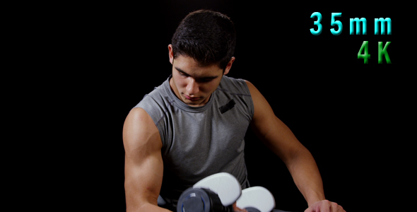 Young Man Working On Biceps With Dumbbells 20