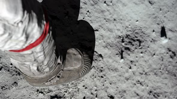 Lunar astronaut walking on the moon's surface and leaves a footprint in the lunar soil