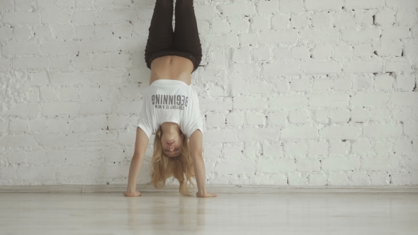 Young Sportive Girl Show Acrobatic Tricks Against The Wall alt