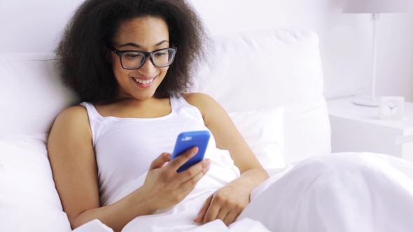 African Woman With Smartphone In Bed At Home 81 alt