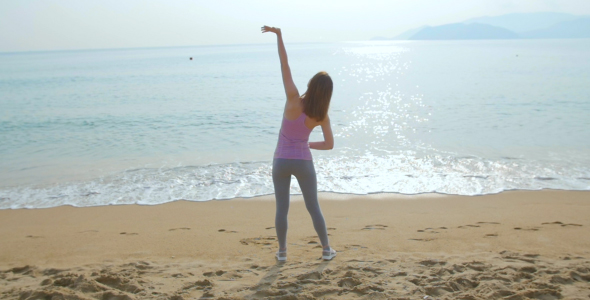 Young Woman Doing Exercises on the Beach