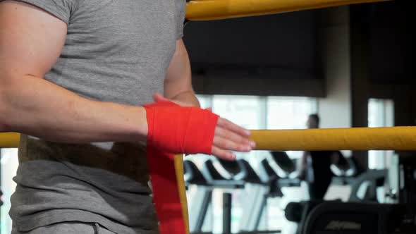 Cropped Shot of a Male Boxer Applying Wrist Bandages Before Boxing