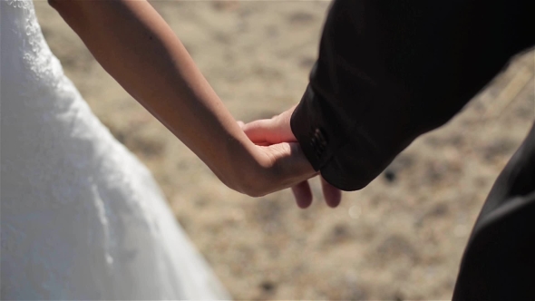 Newly Married Couple Walk Together Holding Hands alt
