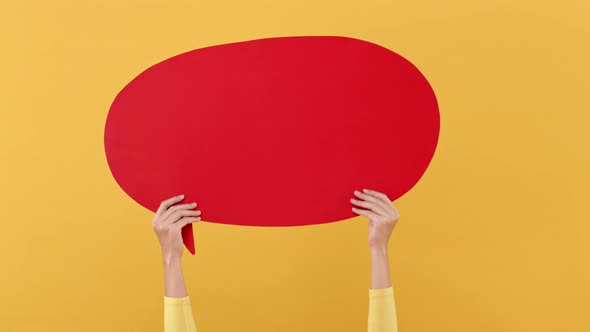 Woman hands holding red speech bubble with empty space for text on yellow background