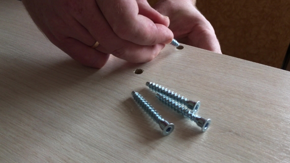 Man Assembles Parts Of Furniture 