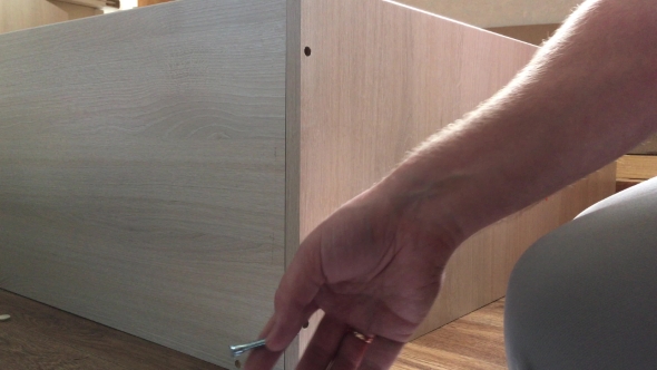 Man Assembles Parts Of Furniture 