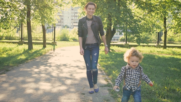 Melenko Boy Walking Along a Path In a Park. Nice Young Girl Watching Him Taken With a Sony Camera,  alt