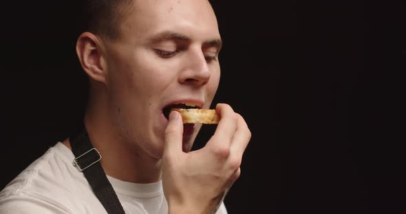 A Young Man Enjoys Eating A Piece Of Fresh Homemade Bread