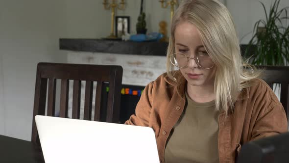 Woman developer coding on laptop computer. Front view