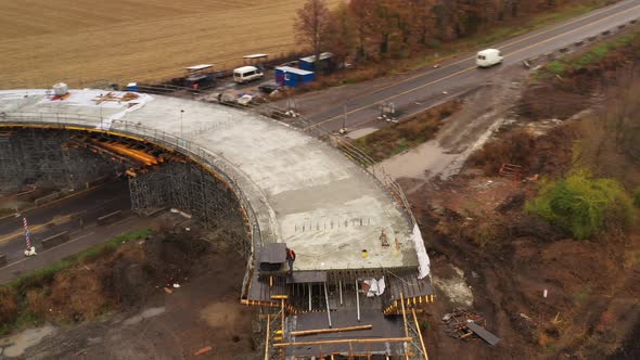 Drone Orbit Shot - a Worker Inspects the Construction of the Roadway on the Overpass  alt