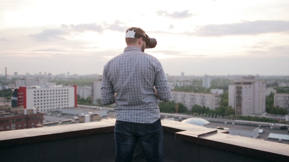 Man Uses a Virtual Reality Glasses On The Roof alt
