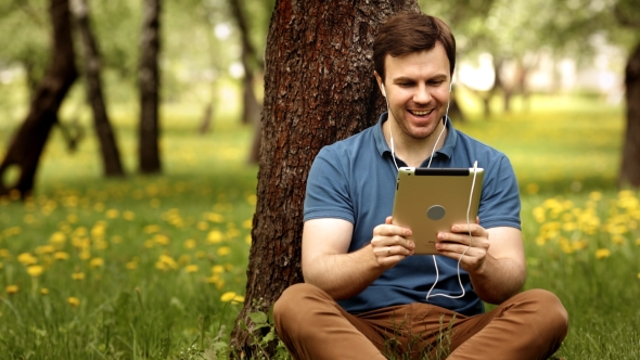 Handsome Hipster Man Talk Using His Tablet Pc On a Sunny Day alt