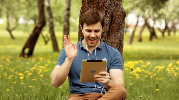 Handsome Hipster Man Talk Using His Tablet Pc On a Sunny Day