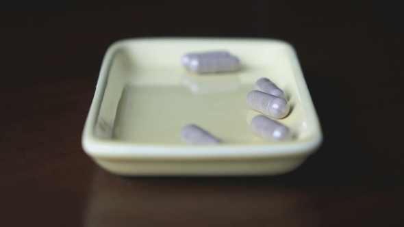 Capsules Are Scattered In a Container On The Table