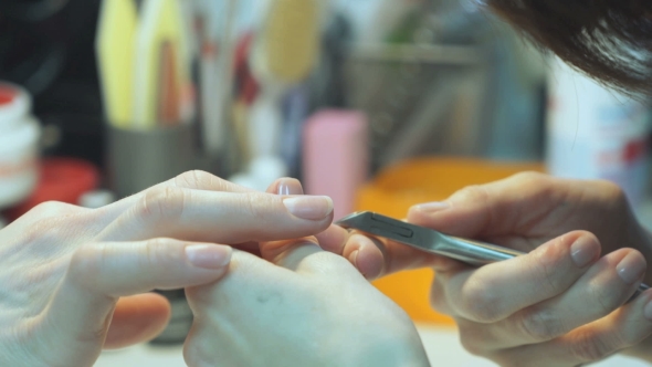 A Female Master Makes Manicure Of Hands Girl