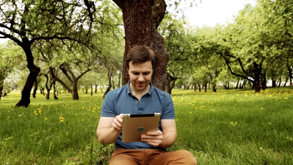 Handsome Hipster Man Using His Tablet Pc On a Sunny Day With Copy Space alt