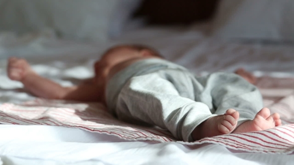 Newborn Baby Lying On a Bed