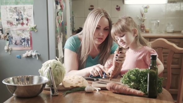 Mother Peeling Carrot With Daughter alt