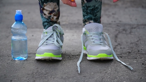 Girl Stopped Running To Tie The Laces On Running Shoes. Fitness Girl Training Outdoors.  alt