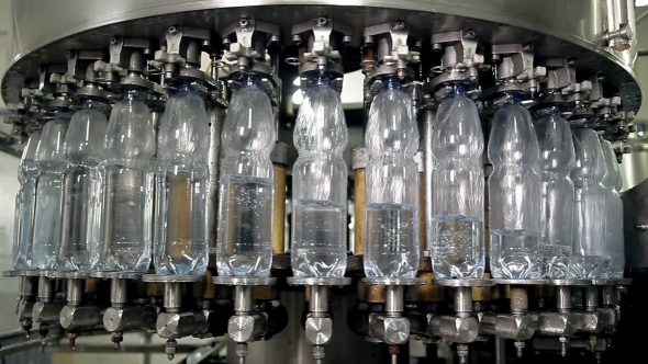 The Machine Is Pouring Mineral Water Into Bottles alt