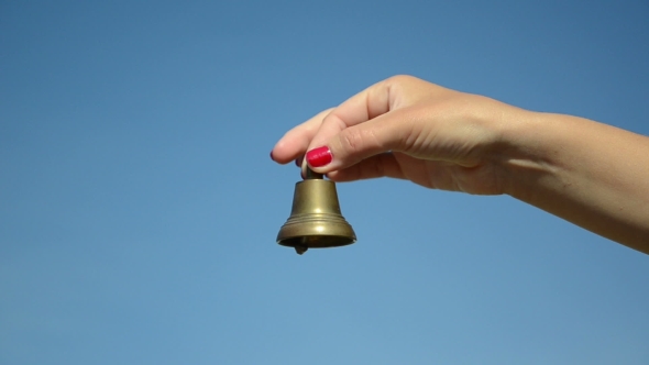 Teacher Hand With Red Nails Ring Bronze Bell On Blue Sky