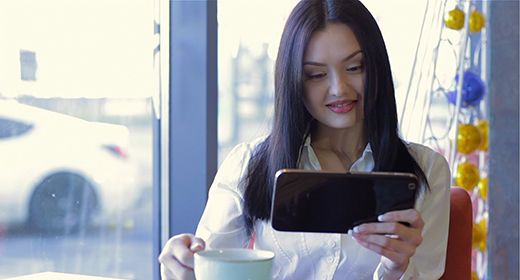 Girl working with a laptop and ordering food in a cozy cafe